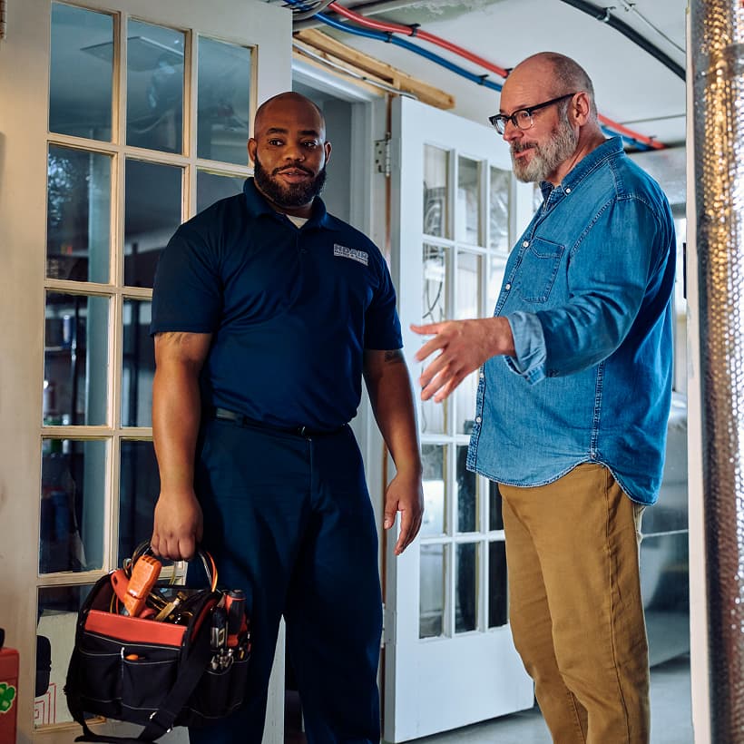 A Hurley and David technician discusses the repair and installation services with a homeowner.