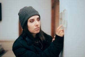 woman trying to turn heat up on a short cycling furnace