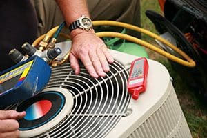 an AC contractor checking a HVAC unit outside a residential home for heating repair and ac tune up