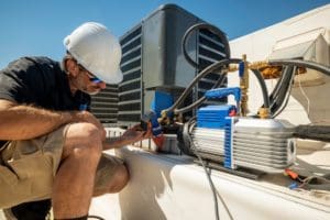 HVAC technician monitoring a condensate pump after an air conditioning repair
