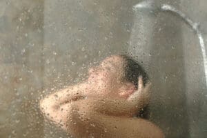 woman enjoying a shower with hot water from a tankless water heater