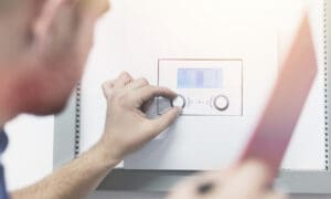 plumber adjusting the temperature of a hot water heater
